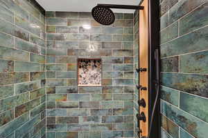 Full bath featuring tiled shower