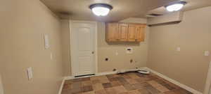 Laundry area with a textured ceiling, hookup for a washing machine, cabinet space, gas dryer hookup, and hookup for an electric dryer