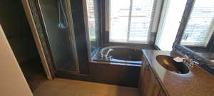 Full bath with vanity, a stall shower, a whirlpool tub, and light tile patterned flooring