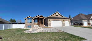 Craftsman house featuring a garage, stucco siding, concrete driveway, and stone siding