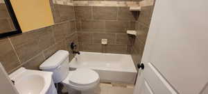 Bathroom featuring tile walls and  shower combination