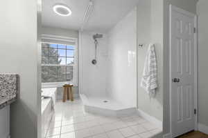 Bathroom with a marble finish shower and light tile patterned floors