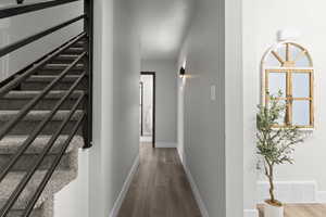 Corridor with wood finished floors and a textured ceiling