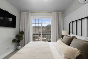 Bedroom featuring access to exterior and baseboards
