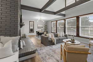 Living room featuring light wood-style floors, beam ceiling, and hanging lights