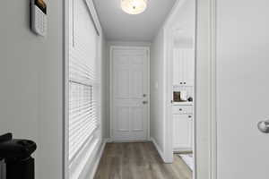 Doorway to outside with wood finished floors and baseboards