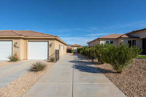 View of home's exterior featuring stucco siding, concrete driveway, and a garage