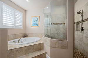 Full bath featuring a walk in shower, a bath, and recessed lighting