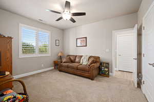 Living room with light colored carpet and ceiling fan