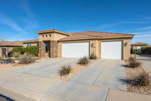 Prairie-style home with stucco siding, an attached garage, concrete driveway, and a tile roof
