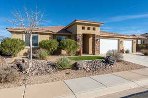 Prairie-style home with stucco siding, a garage, stone siding, concrete driveway, and a tiled roof
