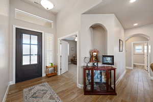 Foyer featuring wood tiled floors, arched walkways, and a ceiling fan