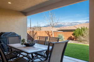 Fenced backyard with outdoor dining area, a mountain view, grilling area, and a patio area