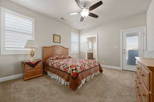 Bedroom featuring access to outside, ceiling fan, light colored carpet, and ensuite bath