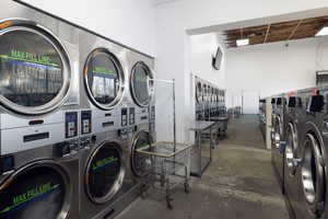 Community laundry with stacked washer / dryer and a high ceiling