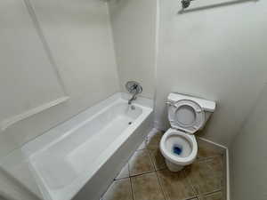 Full bath featuring light tile patterned floors and toilet