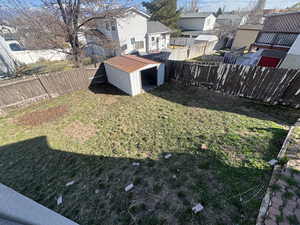 Fenced backyard with a residential view and a shed
