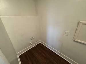 Laundry room with hookup for a gas dryer and dark wood-type flooring