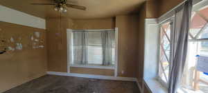 Carpeted spare room featuring ceiling fan and baseboards