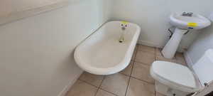 Bathroom featuring a freestanding bath and light tile patterned flooring
