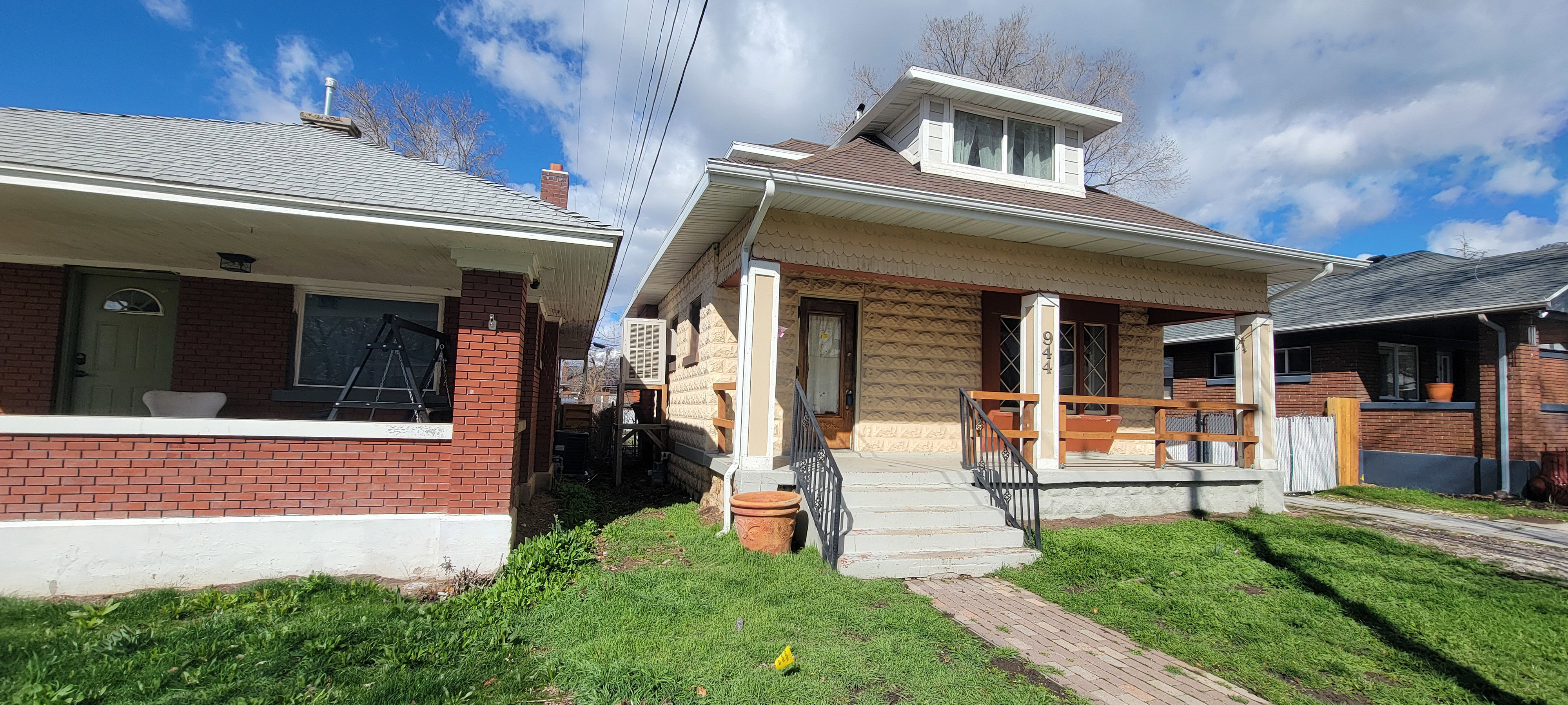 Bungalow-style home with a porch, a front lawn, brick siding, and roof with shingles