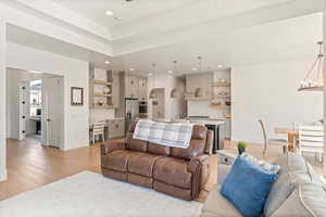 Living area with light wood-type flooring and a chandelier