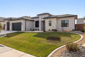 Prairie-style home featuring stone siding, stucco siding, an attached garage, driveway, and a tiled roof