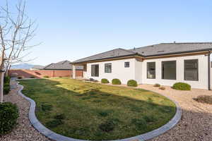 Rear view of house with stucco siding and a fenced backyard