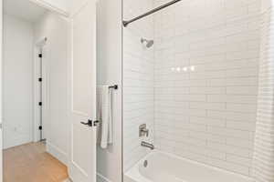 Bathroom featuring shower / bath combination with curtain and light wood finished floors
