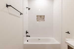 Bathroom featuring washtub / shower combination and vanity