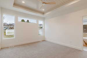 Spare room featuring a wood tray ceiling, light carpet, a ceiling fan, and recessed lighting