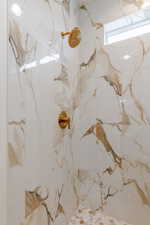 Bathroom featuring a marble finish shower