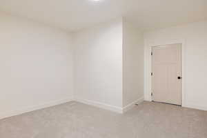 Unfurnished room featuring light colored carpet and baseboards