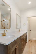 Bathroom featuring recessed lighting, double vanity, and light wood-type flooring