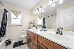 Full bath featuring double vanity and light tile patterned flooring