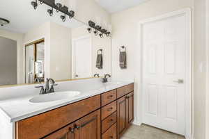 Full bath featuring double vanity and light tile patterned floors