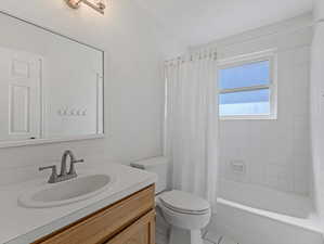 Bathroom with vanity, shower / bath combination with curtain, and light tile patterned floors