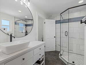 Main ensuite bathroom with vanity, a shower stall, and recessed lighting
