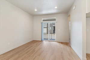 Empty room with light wood-style floors and recessed lighting