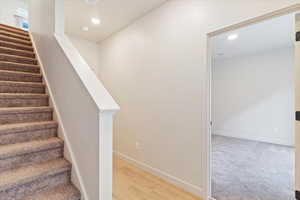 Stairway featuring recessed lighting and wood finished floors