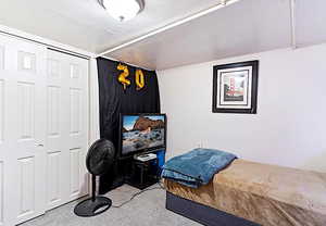 Bedroom with a textured ceiling and a closet