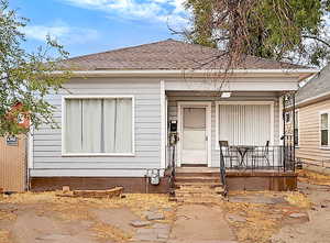 View of front of property with a shingled roof and a porch