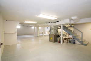 Basement featuring stairs and heating unit