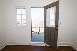 Doorway to outside featuring baseboards and wood finished floors