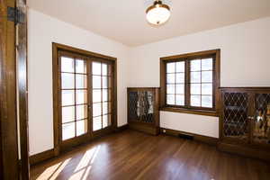 Spare room with french doors, dark wood finished floors, and healthy amount of natural light