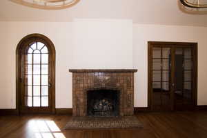 Unfurnished living room featuring dark wood-style flooring and a fireplace