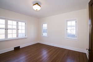 Unfurnished room featuring dark wood finished floors and crown molding