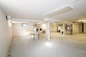 Basement featuring washer and clothes dryer, heating unit, and gas water heater