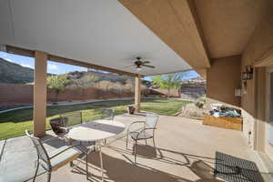 Fenced backyard with a patio area and ceiling fan