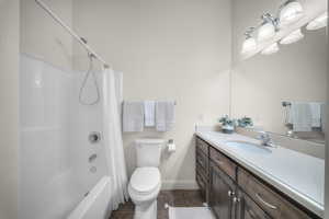 Bathroom with vanity, shower / bathtub combination with curtain, and dark tile patterned flooring